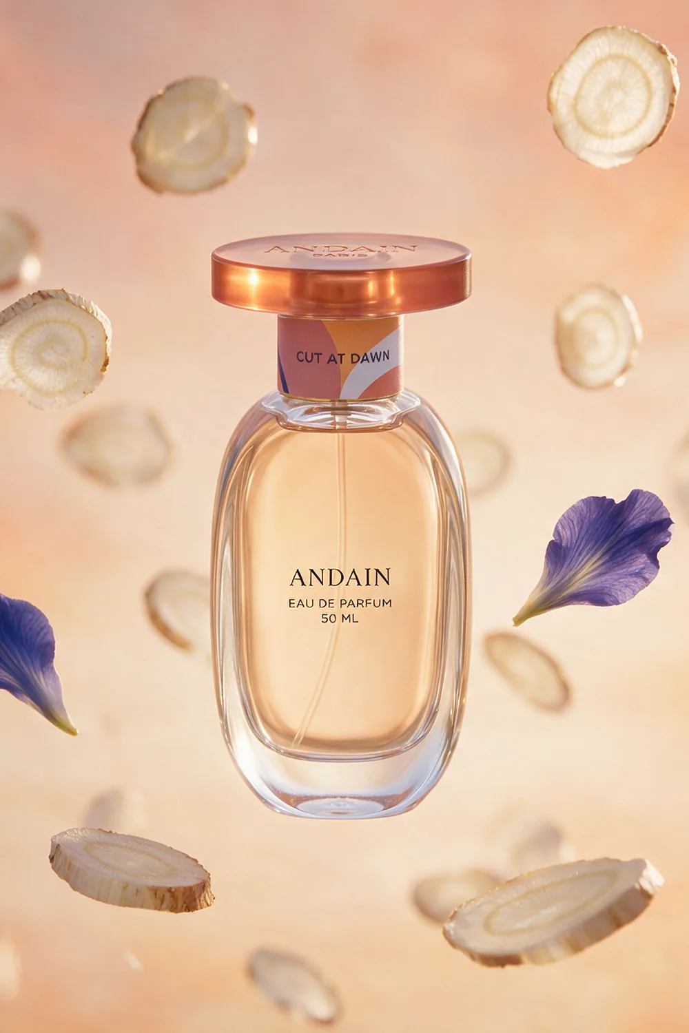 The perfume bottle among suspended slices of orris root.