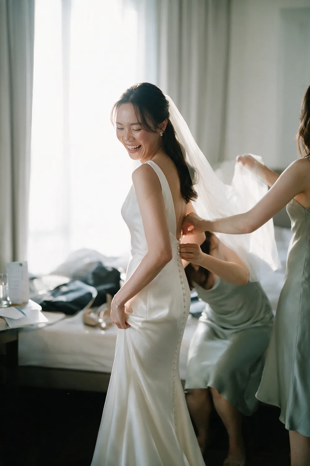 The dress being fastened beside a window.