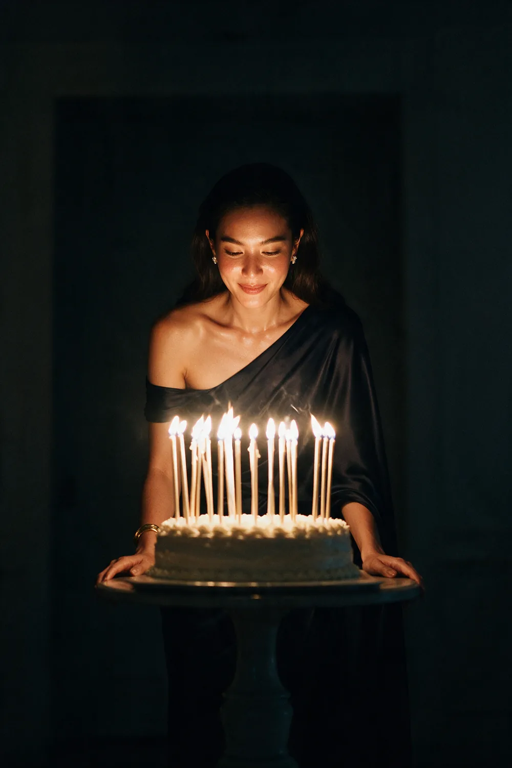 A cake carried in the dark, the candles the only light.